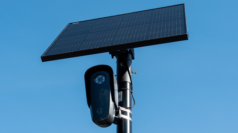 A Flock camera and solar panel mounted on top of a pole