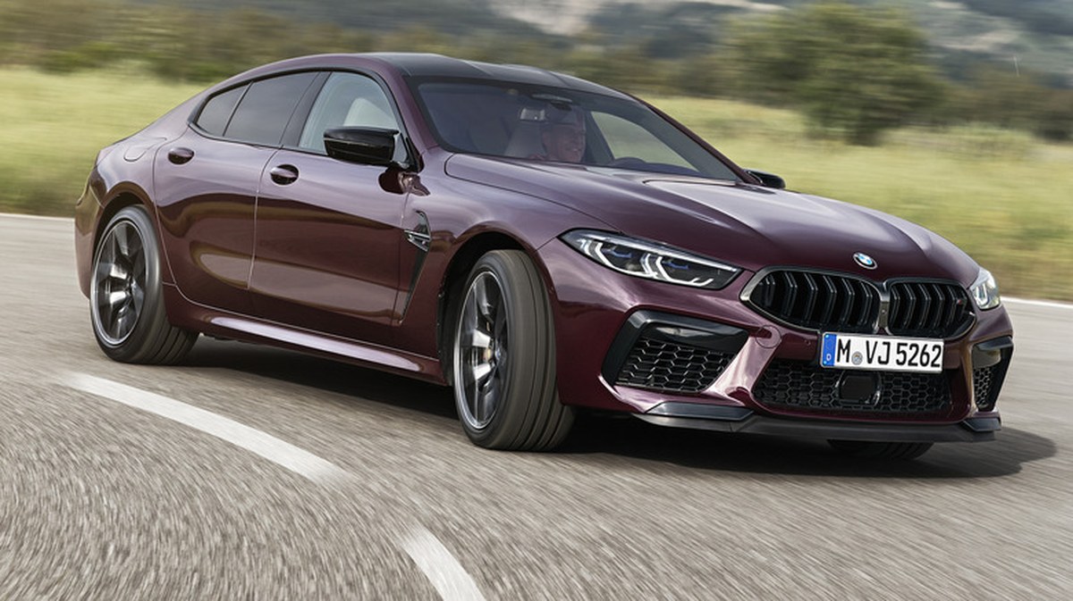 A 2021 BMW M8 Gran Coupe in purple ripping down a winding road.