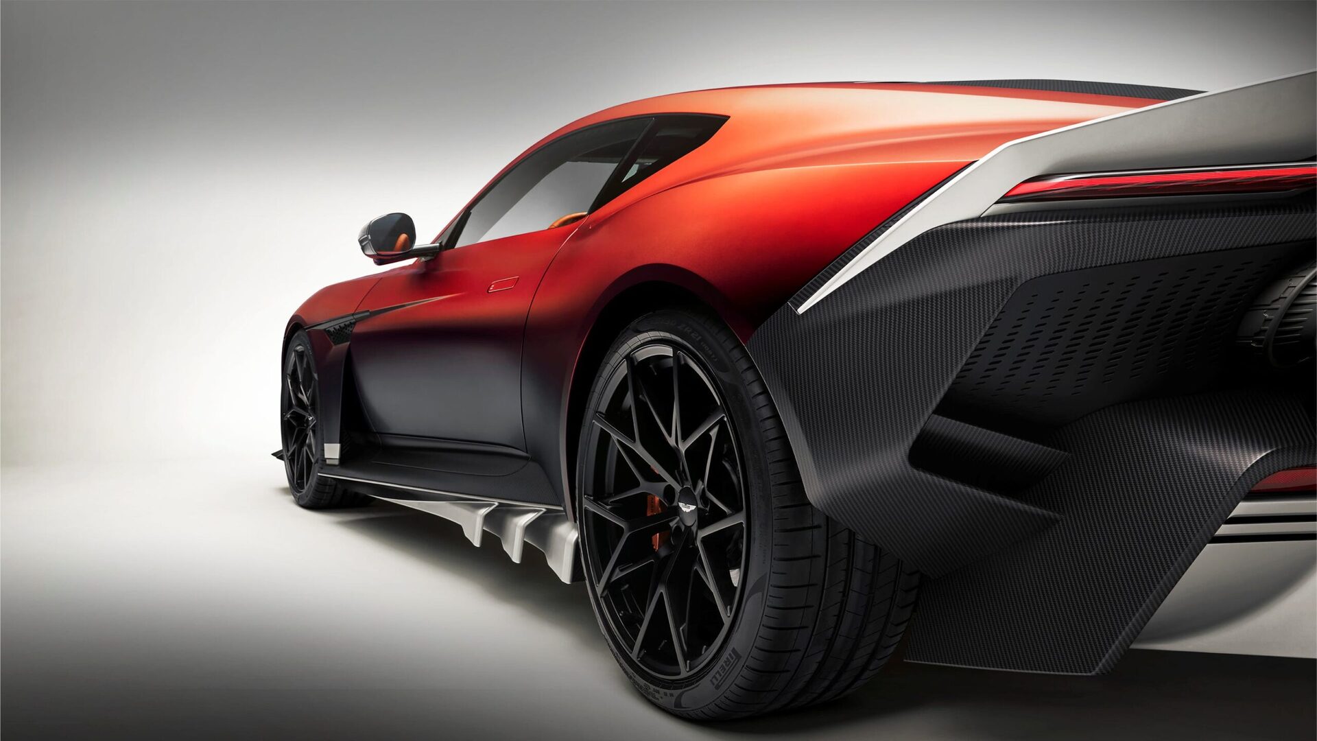 A sleek, modern sports car in red and black with distinctive wheels and aerodynamic design features.