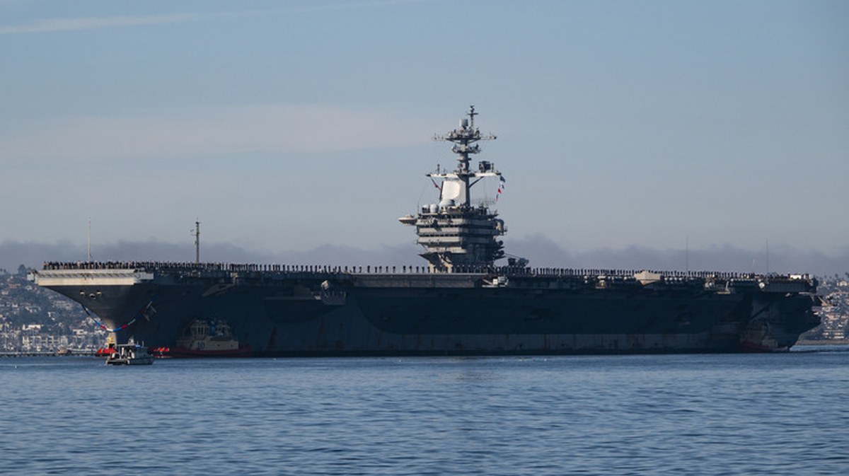 SAN DIEGO, CALIFORNIA - DECEMBER 20: Sailors and marines man the rail as the U.S. Navy Nimitz-class aircraft carrier USS Abraham Lincoln (CVN 72) is guided by tugboats in San Diego Bay as it returns to its homeport of Naval Air Station North Island after a 5-month deployment to the Middle East on December 20, 2024 in San Diego, California. (Photo by Kevin Carter/Getty Images)