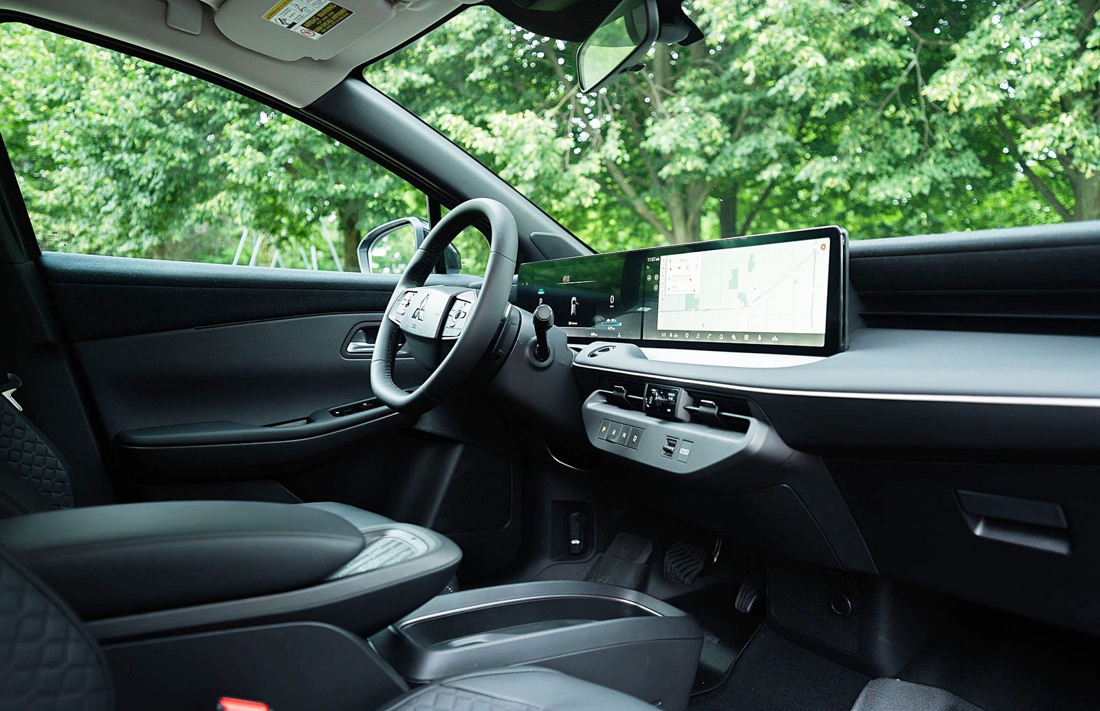 Interior view of a modern car featuring a sleek dashboard and large touchscreen display.