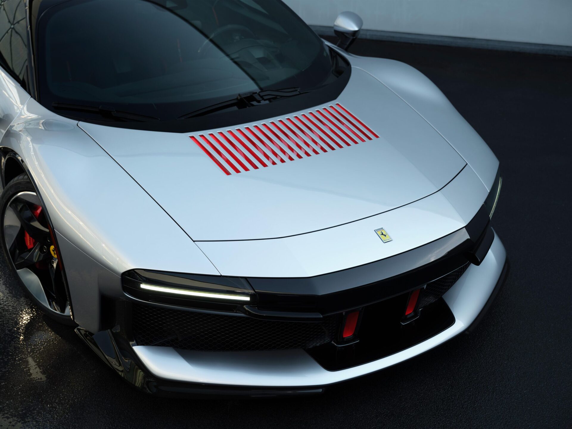 Silver sports car with distinctive red accents on the hood and modern design features.