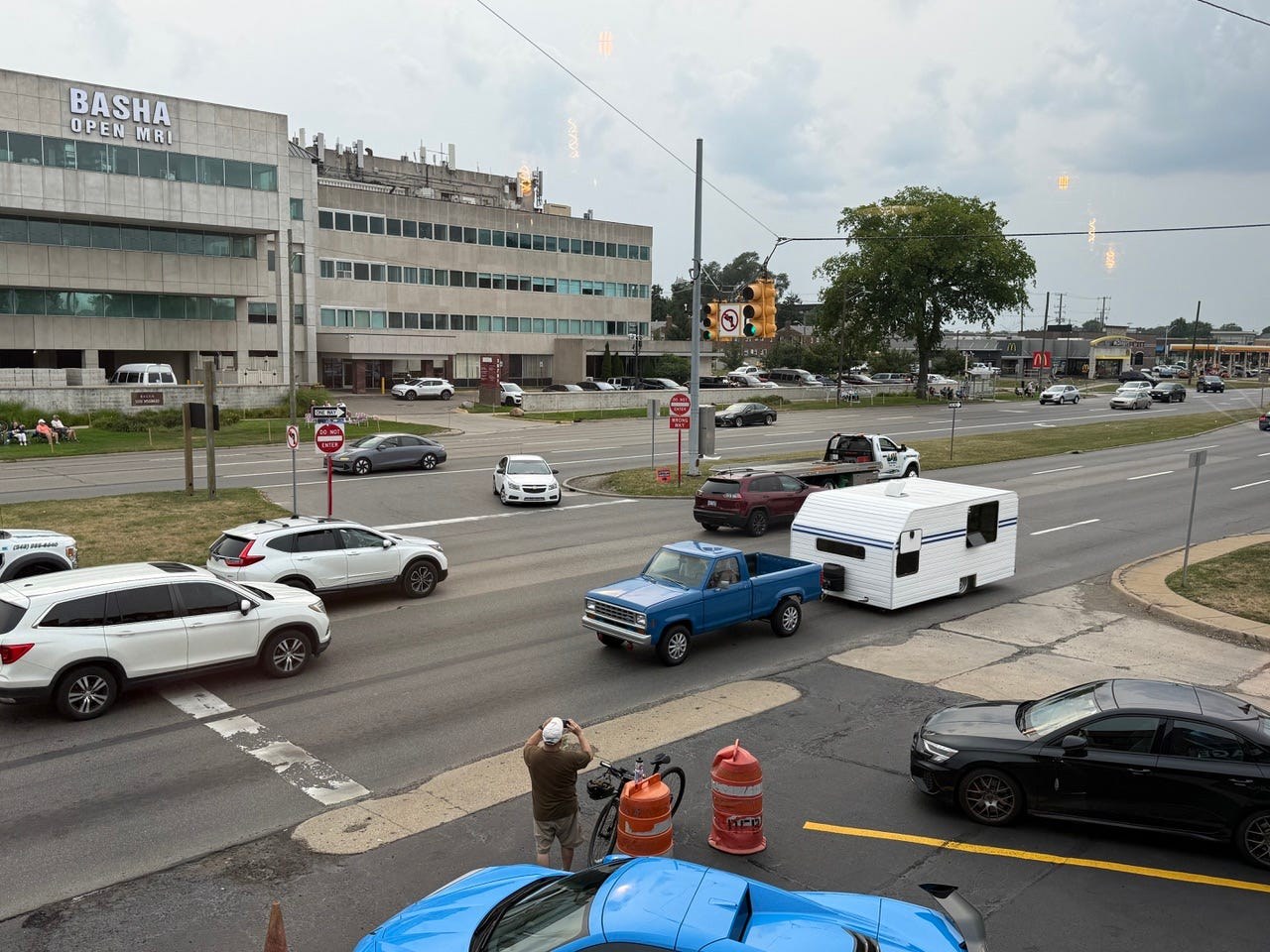 Busy street view with various vehicles and a medical building in the background. Busy street view with various vehicles and a medical building in the background.