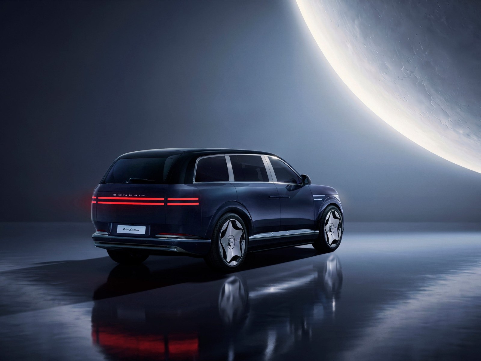 A sleek electric SUV with distinctive taillights, parked against a modern, dramatic backdrop.
