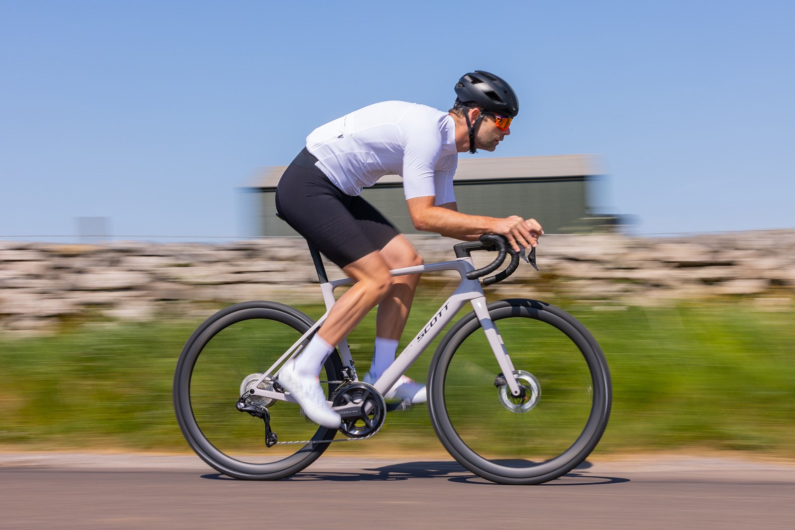 Male cyclist in white top riding the Scott Addict RC 20 road bike