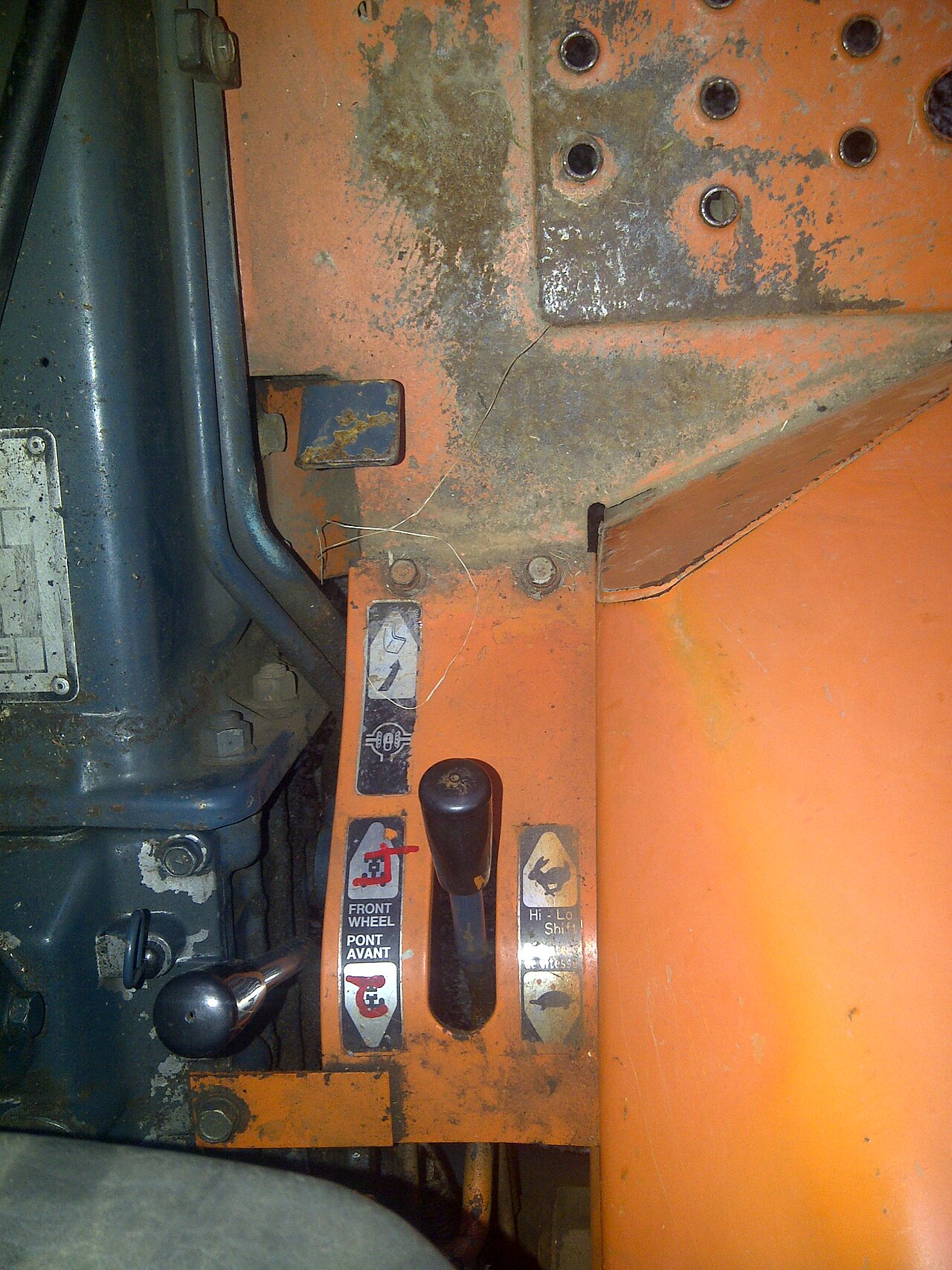 The foot pedal controlling the locking differential on a Kubota B6200. Stepping down on this pedal locks the rear differential. The left lever engages the front axle, and the right one enables selection between high and low speed gearing.