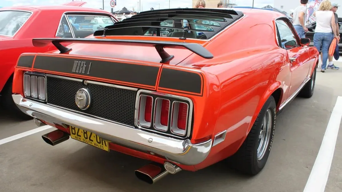 A Ford Mustang Mach 1 sits parked with black rear window louvers visible.