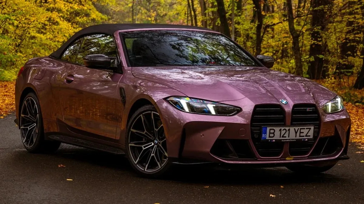 A purple BMW M4 Convertible in a forest