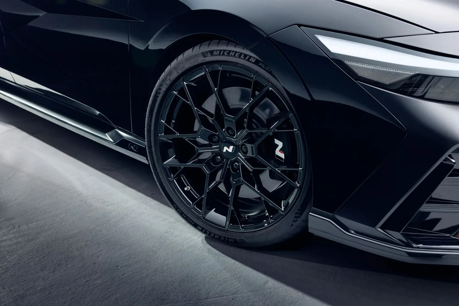 Monochrome forged wheel and front-quarter detail.