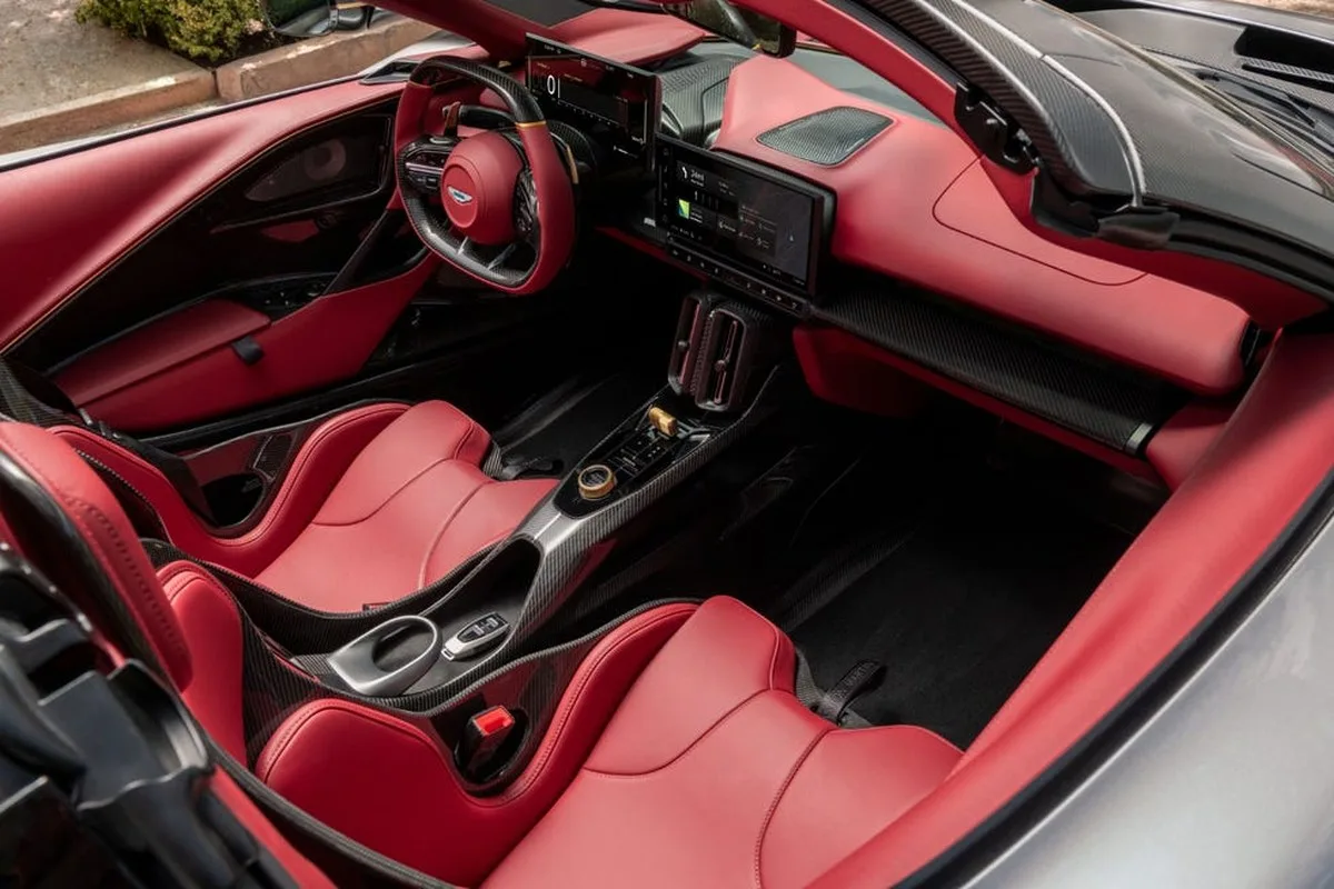 Luxurious car interior featuring red leather seats, carbon fiber details, and modern digital displays. Luxurious car interior featuring red leather seats, carbon fiber details, and modern digital displays.