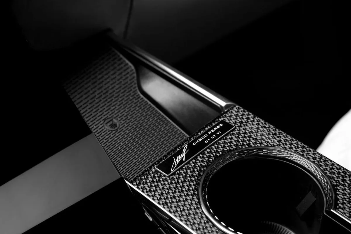 A black and silver console with a cup holder and a nameplate detailing Checo Perez, part of a limited edition.