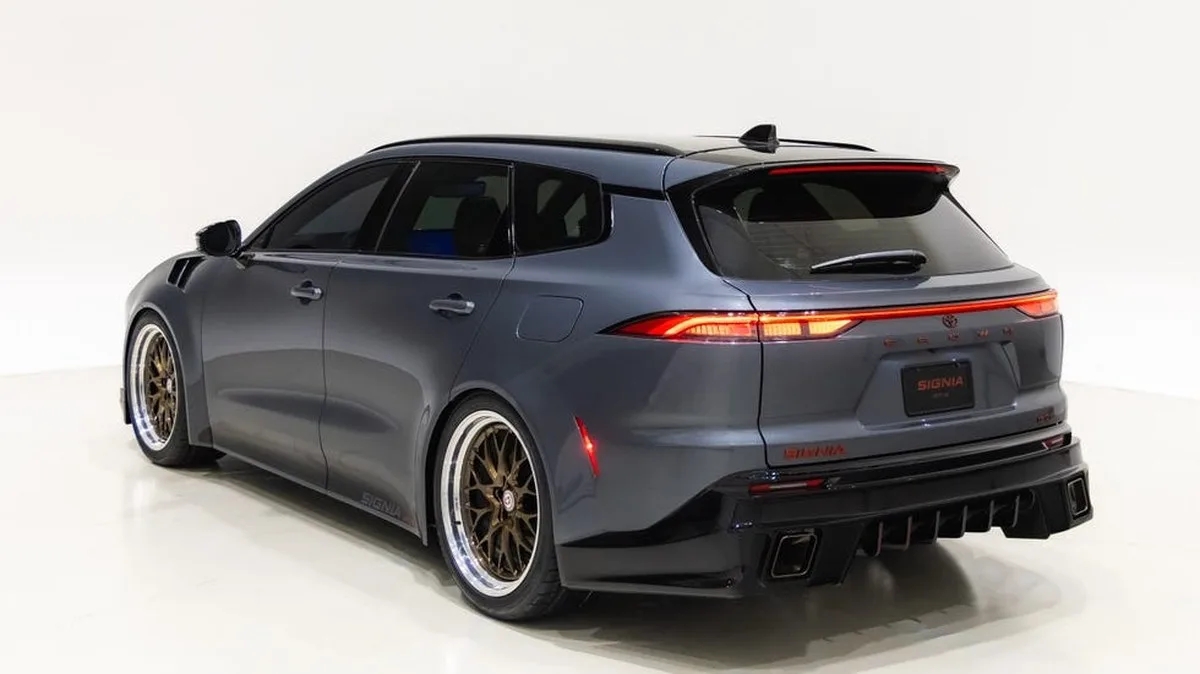 Sporty gray car with custom wheels and a sleek design, showcasing a modern rear view against a plain backdrop.
