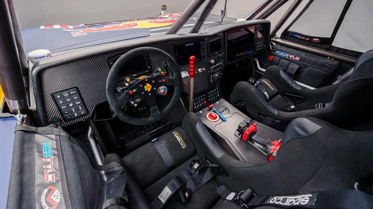 Interior view of a high-performance racing vehicle with advanced controls and two racing seats.