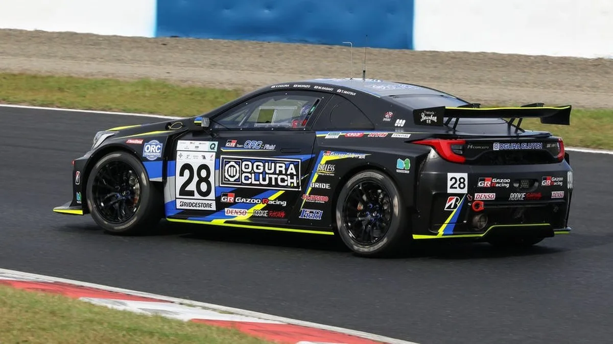 Race car number 28 with black and yellow design speeding around a track. Race car number 28 with black and yellow design speeding around a track.