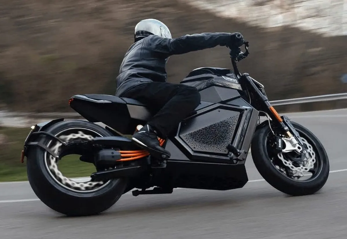 Rider on a black electric motorcycle navigating a winding road. Rider on a black electric motorcycle navigating a winding road.