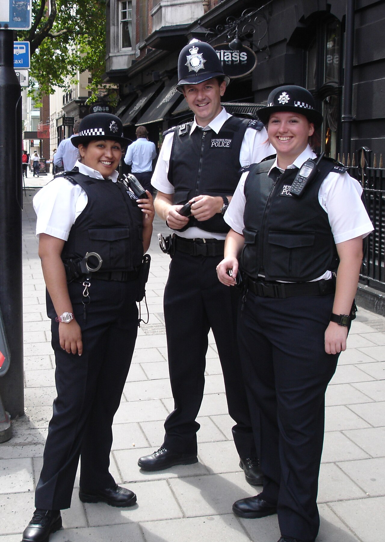 Met Police officers on the streets of Soho. Since 1863, the custodian helmet (middle) has been worn by male police constables and sergeants while on foot patrol.