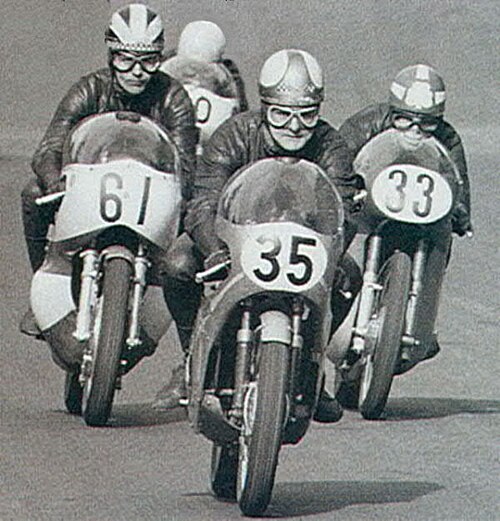 Hailwood 35 leading from the start of a 250 race at Cadwell Park with Phil Read on Yamaha number 61 closely followed by Rod Gould Bultaco 33, around 1967