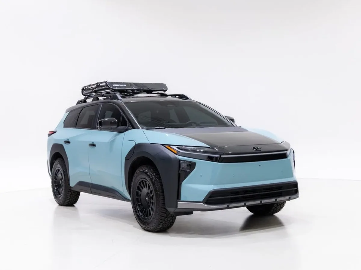 A light blue and black SUV with a roof rack, positioned on a white background. A light blue and black SUV with a roof rack, positioned on a white background.
